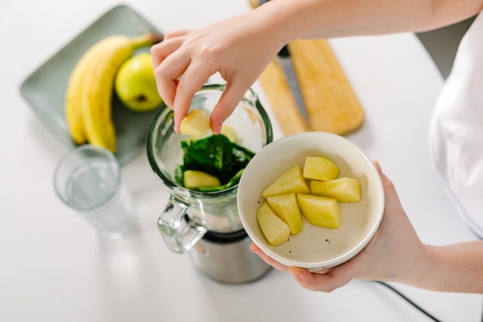 Process of Preparing Green Detox Smoothie with Blender. Vegan Drinks. Concept of Mindful Eating